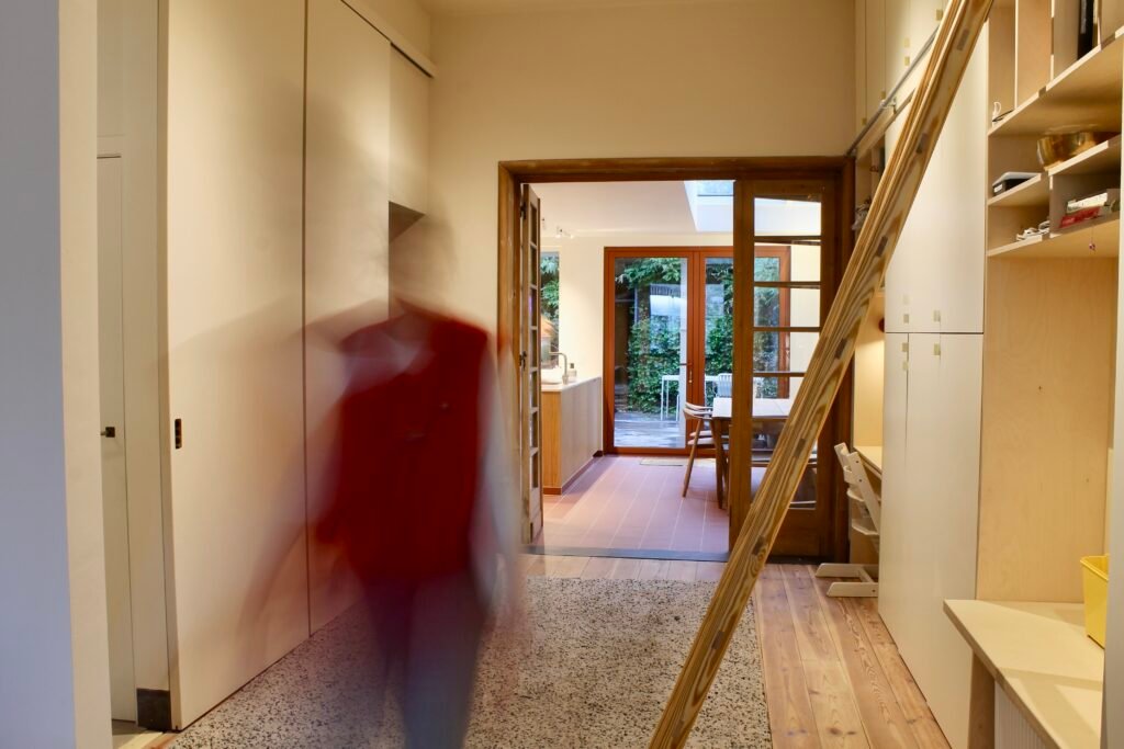 ruimte tussen woonkamer en eetkamer in herenhuis die benut wordt als opslag en bureau